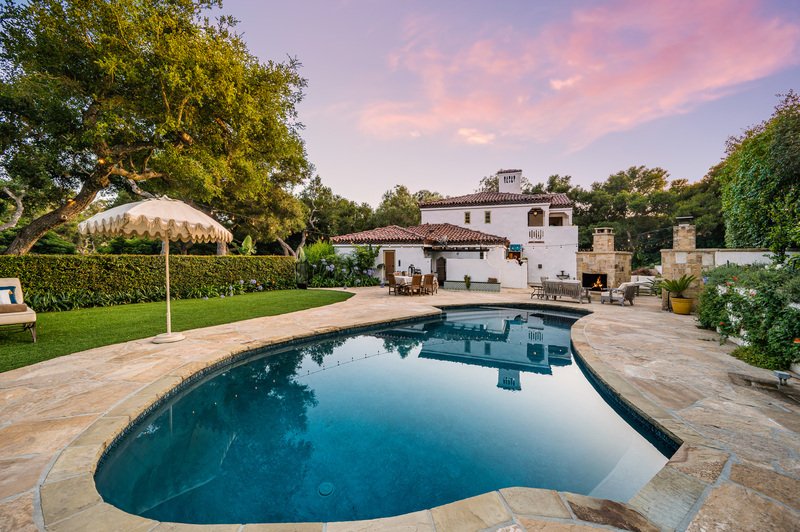 alberca grande en jardin con casa al fondo